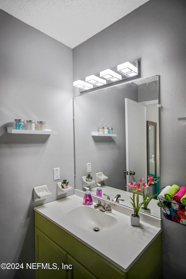 bathroom featuring a textured ceiling and vanity