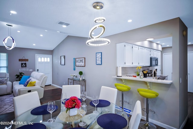 dining space featuring hardwood / wood-style floors and lofted ceiling