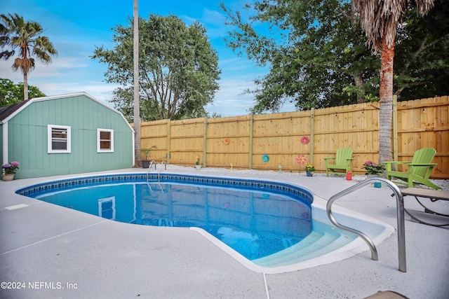 view of swimming pool featuring a patio area and an outdoor structure