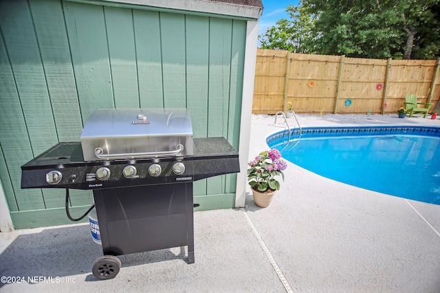 view of swimming pool featuring a patio area and grilling area