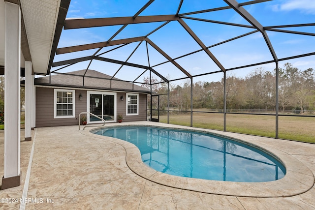 view of swimming pool featuring a yard, a patio area, and glass enclosure