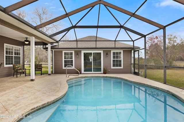 view of swimming pool featuring a patio, ceiling fan, and glass enclosure