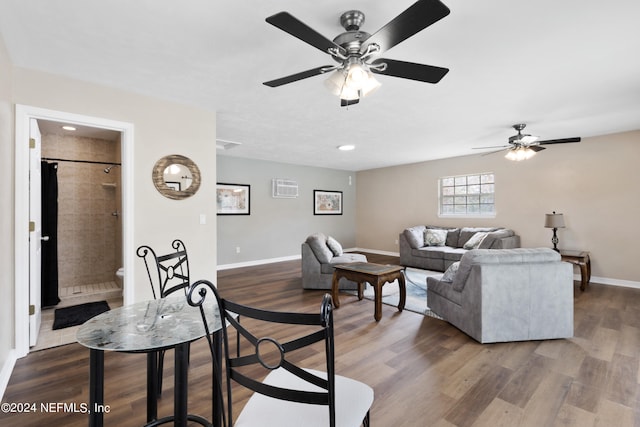 living room featuring ceiling fan and dark hardwood / wood-style floors