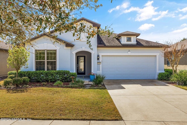 mediterranean / spanish-style house featuring a front lawn and a garage