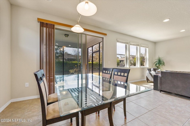 tiled dining area with a textured ceiling