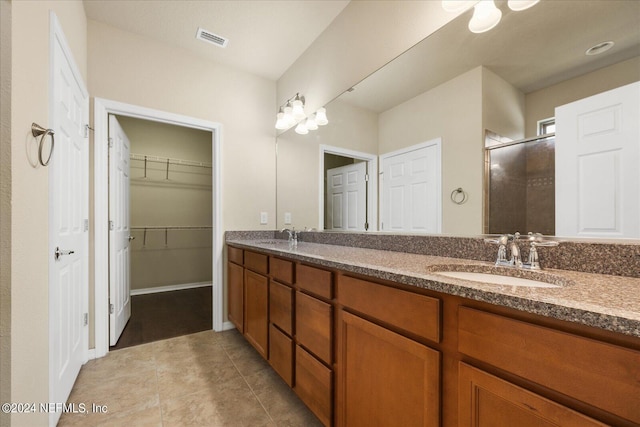 bathroom with vanity, an enclosed shower, and tile patterned flooring