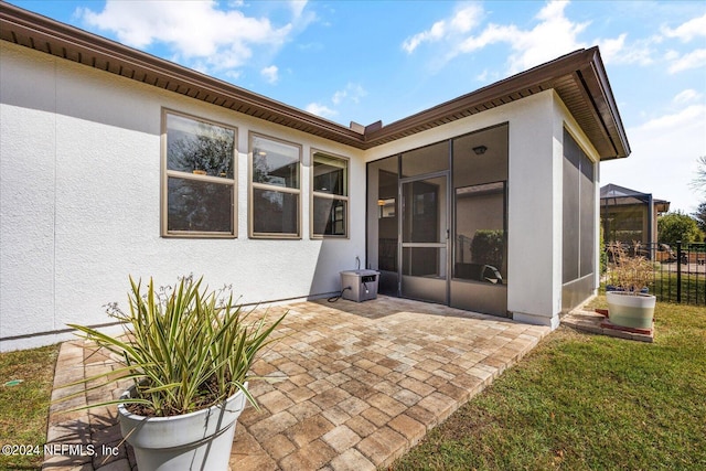 rear view of house with a patio and a sunroom