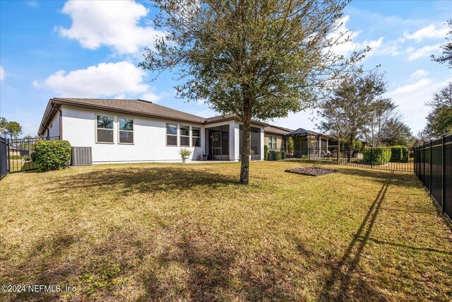 back of property with central AC, a lawn, and a sunroom