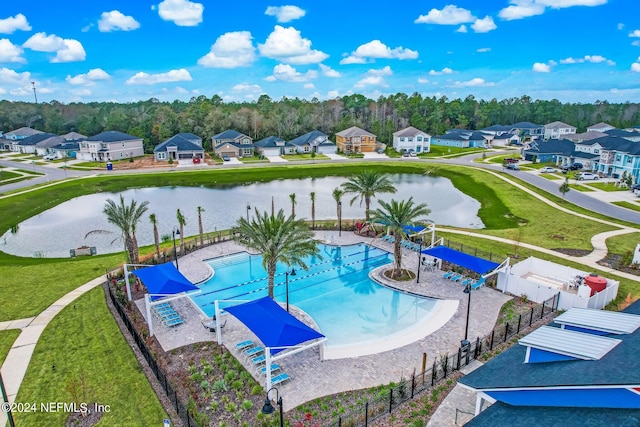 view of swimming pool featuring a water view and a lawn