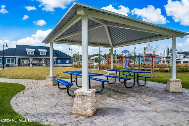 view of property's community featuring a yard, a gazebo, a patio area, and a playground