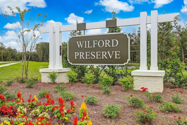 community / neighborhood sign featuring a lawn