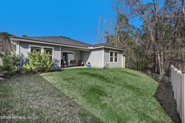 back of property with a lawn and a patio area