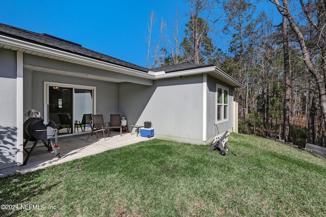 back of house with a patio area and a yard