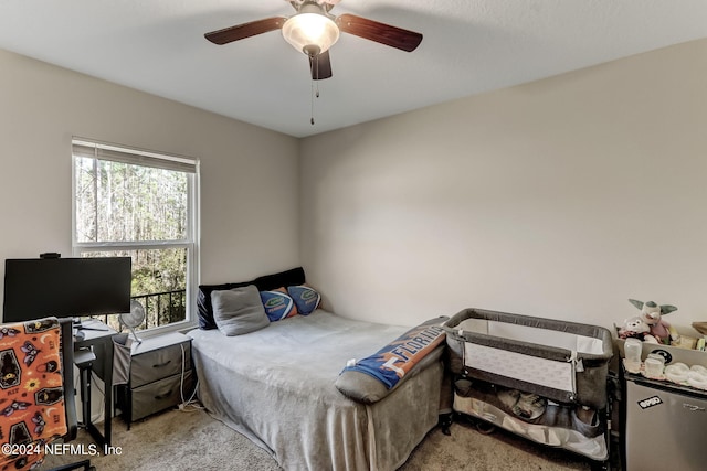 bedroom with light colored carpet, ceiling fan, and refrigerator