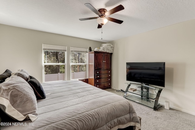 carpeted bedroom with ceiling fan and a textured ceiling