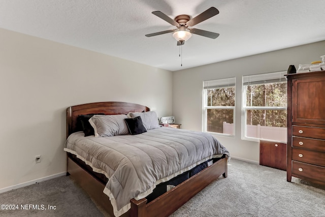 carpeted bedroom with a textured ceiling and ceiling fan