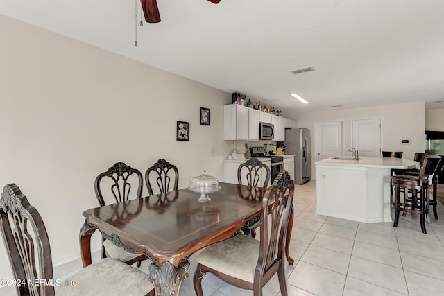 tiled dining space with ceiling fan and sink