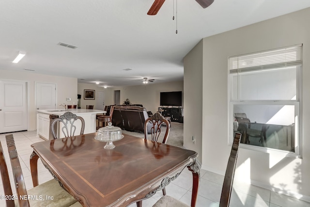 tiled dining space featuring ceiling fan and sink