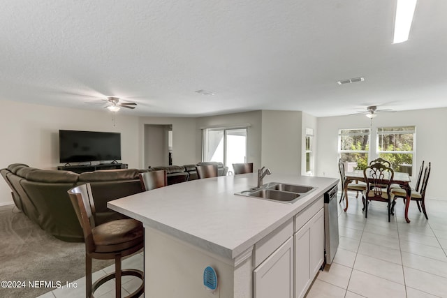 kitchen featuring a center island with sink, ceiling fan, sink, and light tile floors