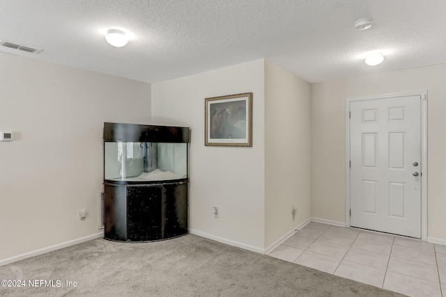 foyer entrance featuring light tile floors and a textured ceiling