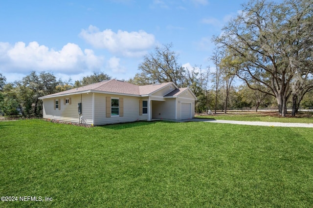 back of house with a lawn and a garage