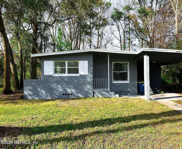 view of front of home with a front lawn and a carport