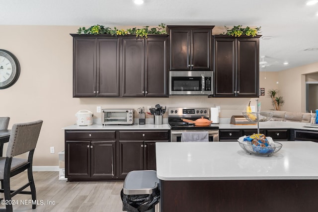 kitchen featuring dark brown cabinets, ceiling fan, light hardwood / wood-style flooring, and appliances with stainless steel finishes