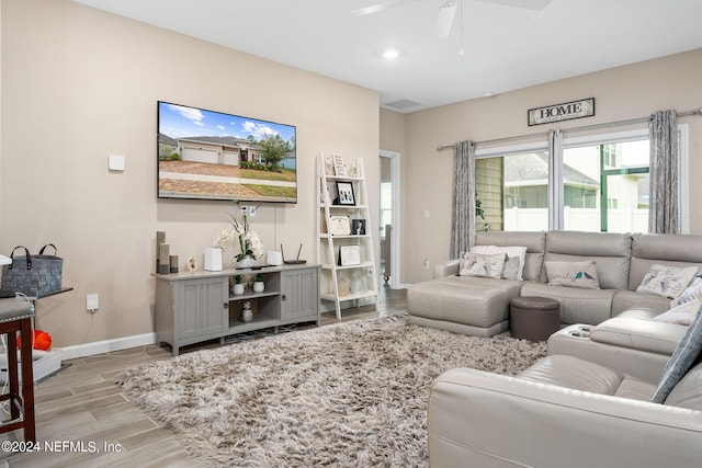 living room featuring light hardwood / wood-style floors and ceiling fan