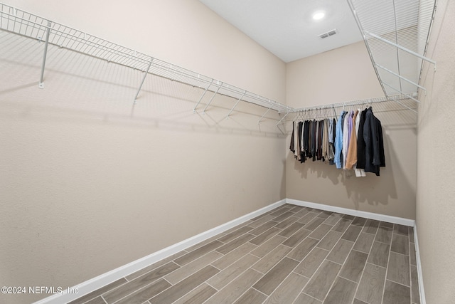 spacious closet with dark hardwood / wood-style flooring