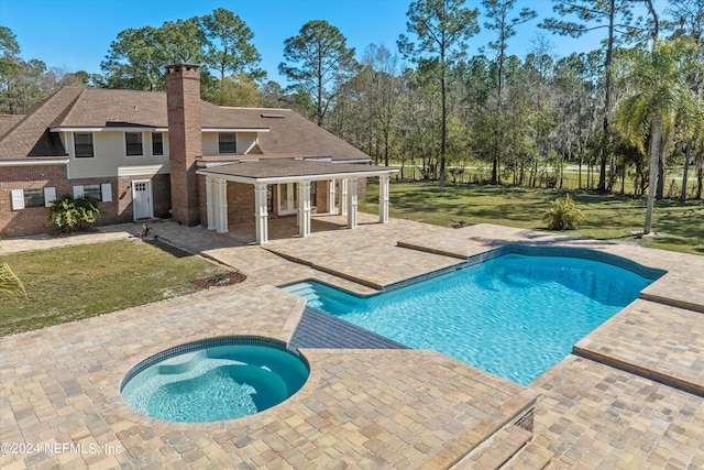 view of swimming pool with a yard, an in ground hot tub, and a patio