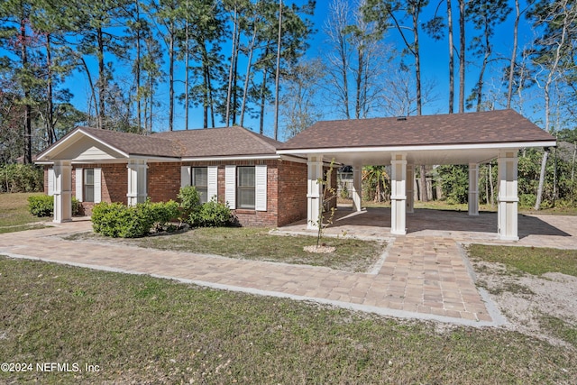 single story home with a front yard and a carport