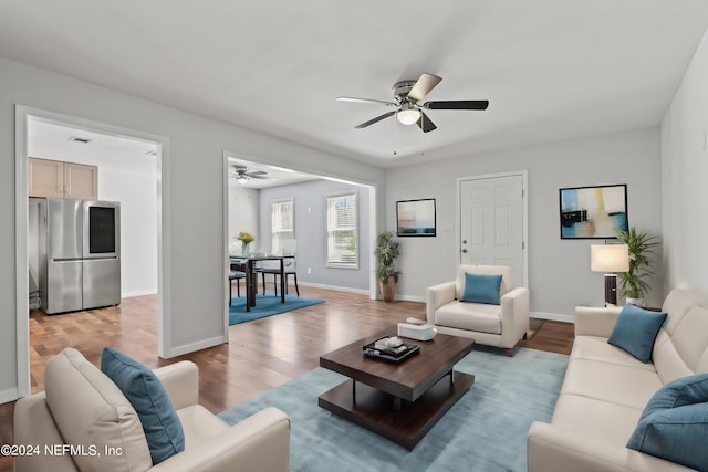 living room with ceiling fan and light wood-type flooring