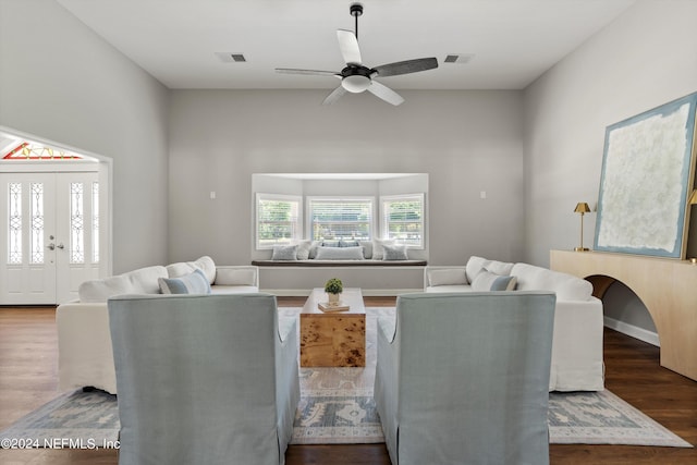 living room featuring ceiling fan and dark wood-type flooring