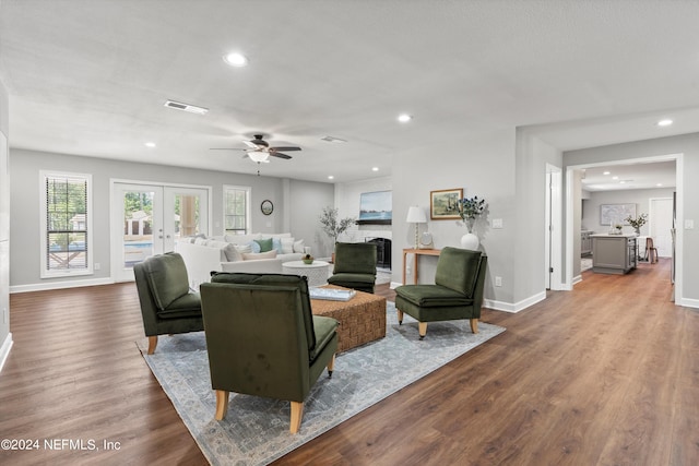 living room featuring wood-type flooring, french doors, and ceiling fan