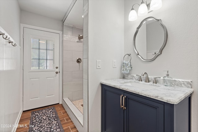 bathroom with tiled shower and vanity