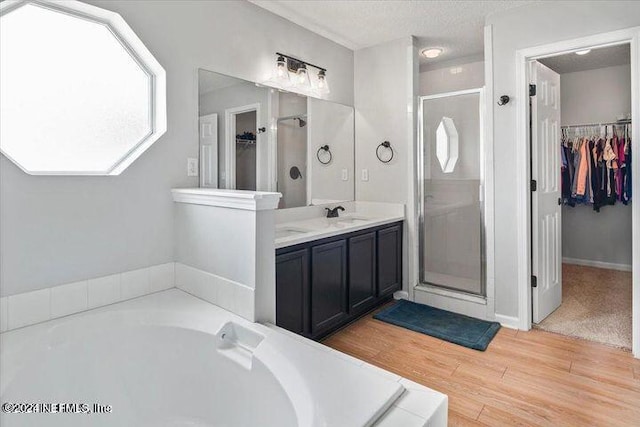 bathroom with independent shower and bath, hardwood / wood-style floors, and vanity