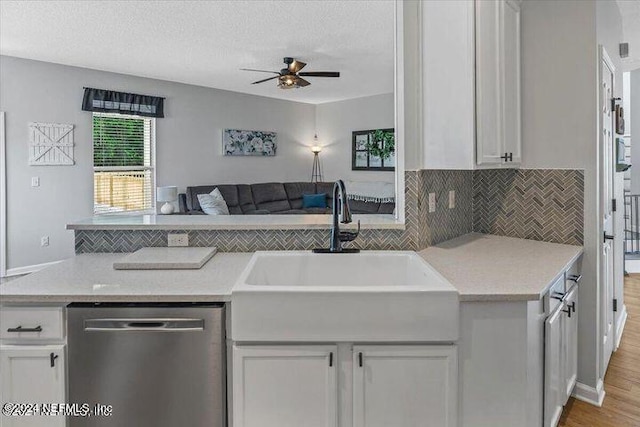 kitchen featuring backsplash, ceiling fan, light hardwood / wood-style floors, white cabinets, and stainless steel dishwasher