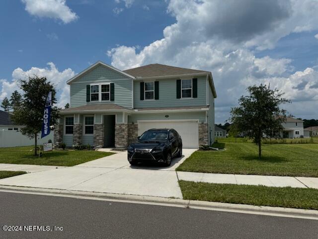 view of front of property featuring a garage and a front lawn