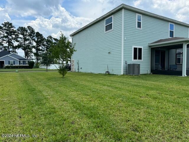 view of home's exterior with a lawn and central AC unit