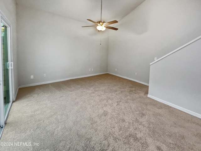 unfurnished room with ceiling fan, vaulted ceiling, and light colored carpet