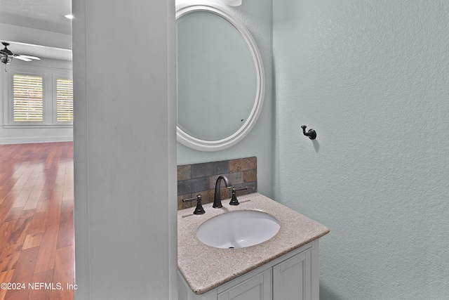 bathroom with ceiling fan, vanity, and hardwood / wood-style flooring