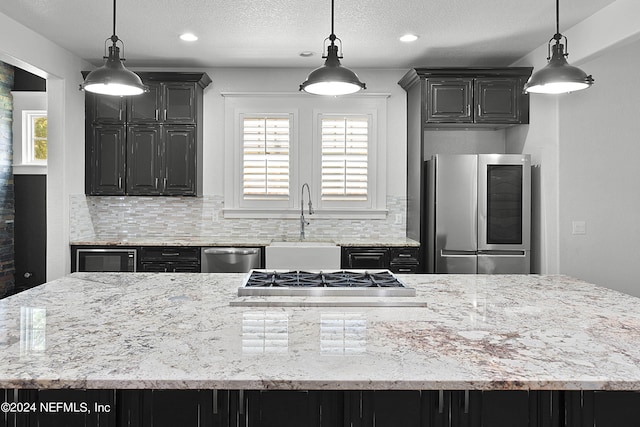 kitchen featuring stainless steel appliances, hanging light fixtures, tasteful backsplash, and a healthy amount of sunlight