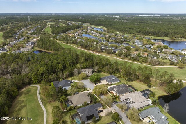 drone / aerial view with a residential view, a water view, and a view of trees