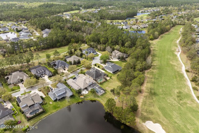 bird's eye view featuring a wooded view, a water view, and a residential view