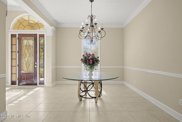 tiled foyer with a notable chandelier, crown molding, and baseboards