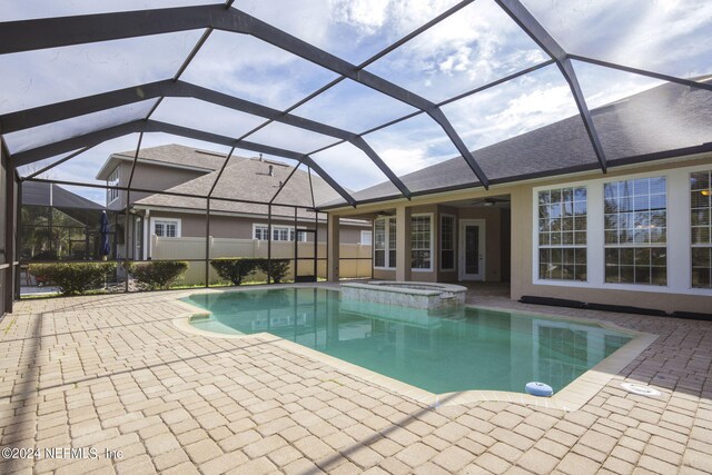 view of swimming pool featuring a patio area, a lanai, a pool with connected hot tub, and a ceiling fan