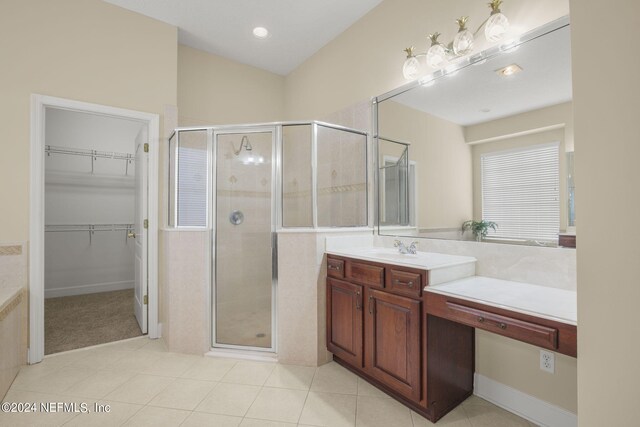 bathroom featuring tile patterned floors, vanity, a spacious closet, and a shower stall