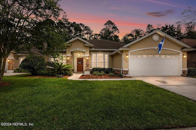 view of front of home with a yard and a garage