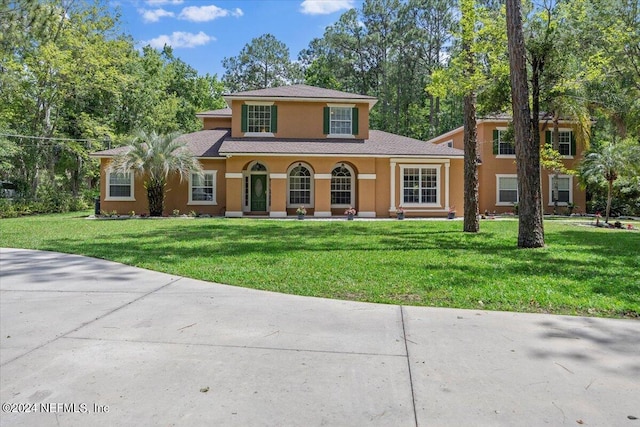 view of front facade with a front yard and stucco siding