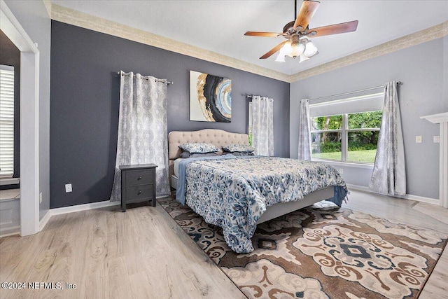 bedroom with ornamental molding, ceiling fan, baseboards, and wood finished floors